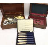 A collection of silver and silver plate within vintage wooden boxes