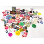 Tin of assorted collectable pin and fabric badges ranging from the 1970s to present.