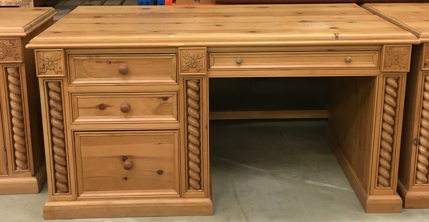 Solid pine desk with 3 side draws and a central draw turned up supports and carved motif