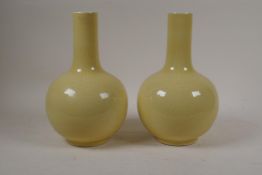 A pair of Chinese pale yellow ground porcelain bottle vases with underglaze lotus flower decoration,