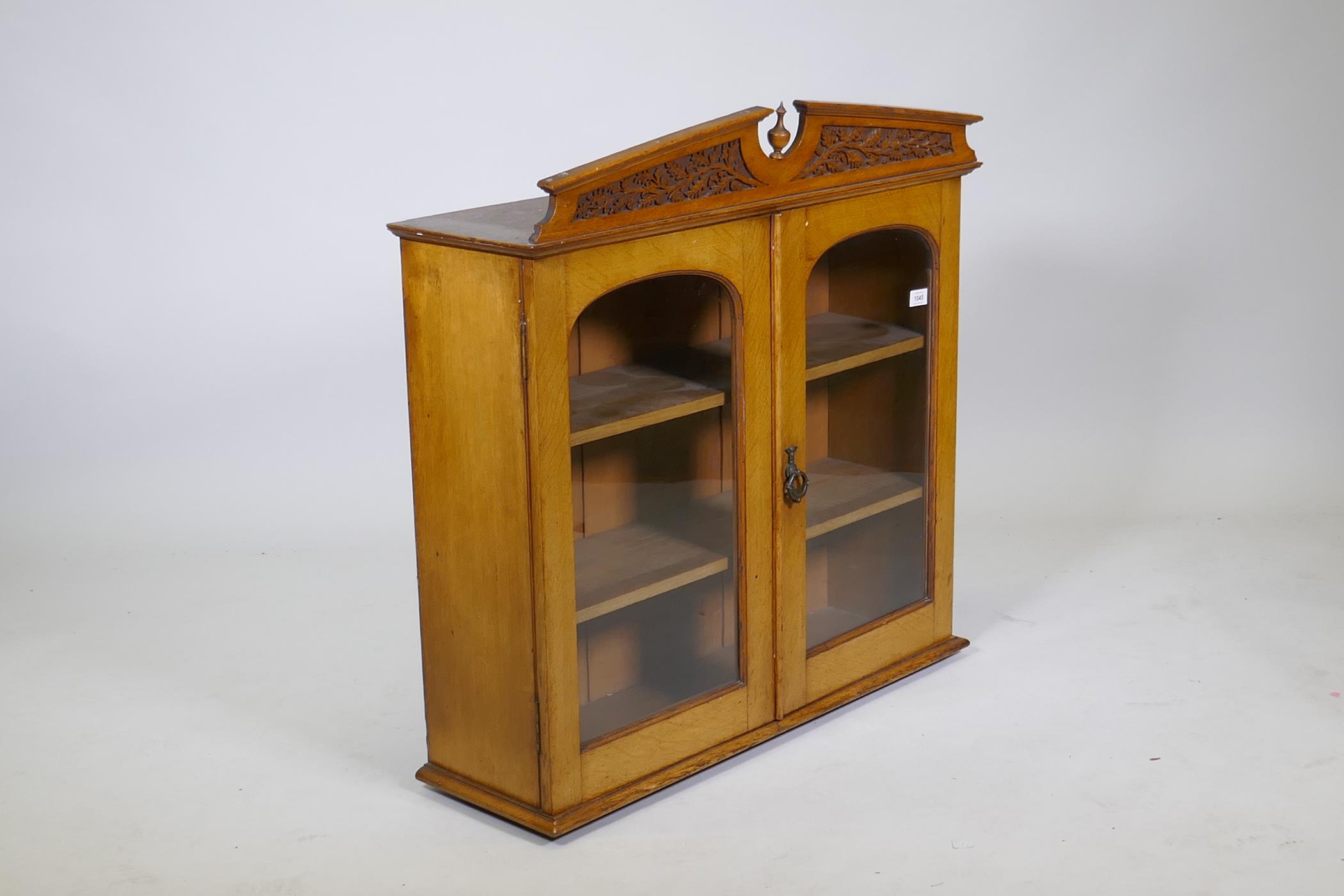 A Victorian golden oak cabinet, with carved oak and acorn pediment and two arched glazed doors, - Image 3 of 3