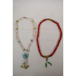 A string of red seed kernel mala beads with jade style feature beads, and a white agate, hardstone