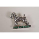 A sterling silver and emerald set brooch in the form of a terrier, 1" long