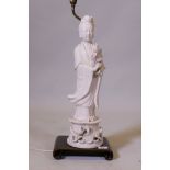 A Chinese blanc de chine figure of Quan Yin, mounted on a wood base as a lamp, AF cracks to base,