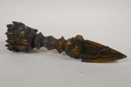 A Tibetan gilt and painted bronze ceremonial phurba with wrathful deity mask decoration, 11" long