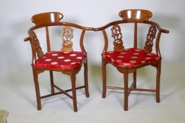 A pair of Chinese hardwood corner chairs, with carved and pierced back splats, late C20th