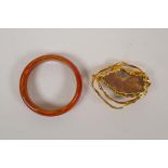 A red banded agate bangle and a gilt metal mounted stone brooch, 3" diameter