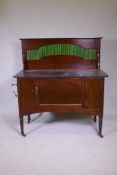 A Victorian mahogany washstand with granite top and tiled back, single cupboard raised on turned