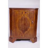 A C19th Italian inlaid walnut cabinet with canted corners and single door, raised on bracket