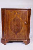 A C19th Italian inlaid walnut cabinet with canted corners and single door, raised on bracket