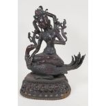 A Sino Tibetan bronze figure of  a goddess seated on a mythical bird, her headdress and necklace set