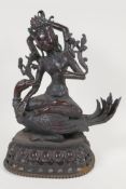 A Sino Tibetan bronze figure of  a goddess seated on a mythical bird, her headdress and necklace set