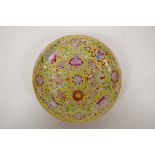 A yellow ground porcelain dish with famille rose enamel decoration of the eight Buddhist symbols,