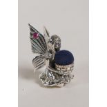 A Sterling silver fairy pincushion with rubies set to the wings, 1" high