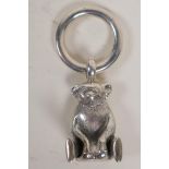 A silver pendant teddy bear and a hoop