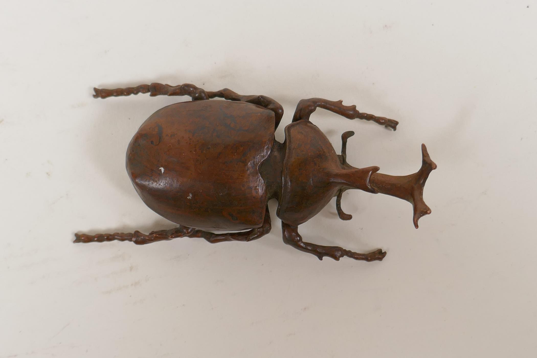 A Japanese Jizai style okimono in the form of a rhinoceros beetle, the carapace opening to reveal an - Image 2 of 5