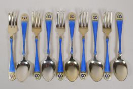A set of silver gilt and enamel cake forks and tea spoons, the handles decorated with borromean
