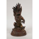A Sino Tibetan bronze figure of a wrathful deity, with coppered and gilt patina, 8½" high