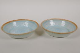A pair of Song style celadon glazed porcelain saucers with underglaze carp decoration, 5" diameter