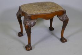 A Georgian style walnut footstool with serpentine shaped seat, raise on carved cabriole supports