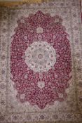 A red ground Kashmir rug with an all over ivory floral medallion design, 89" x 62"