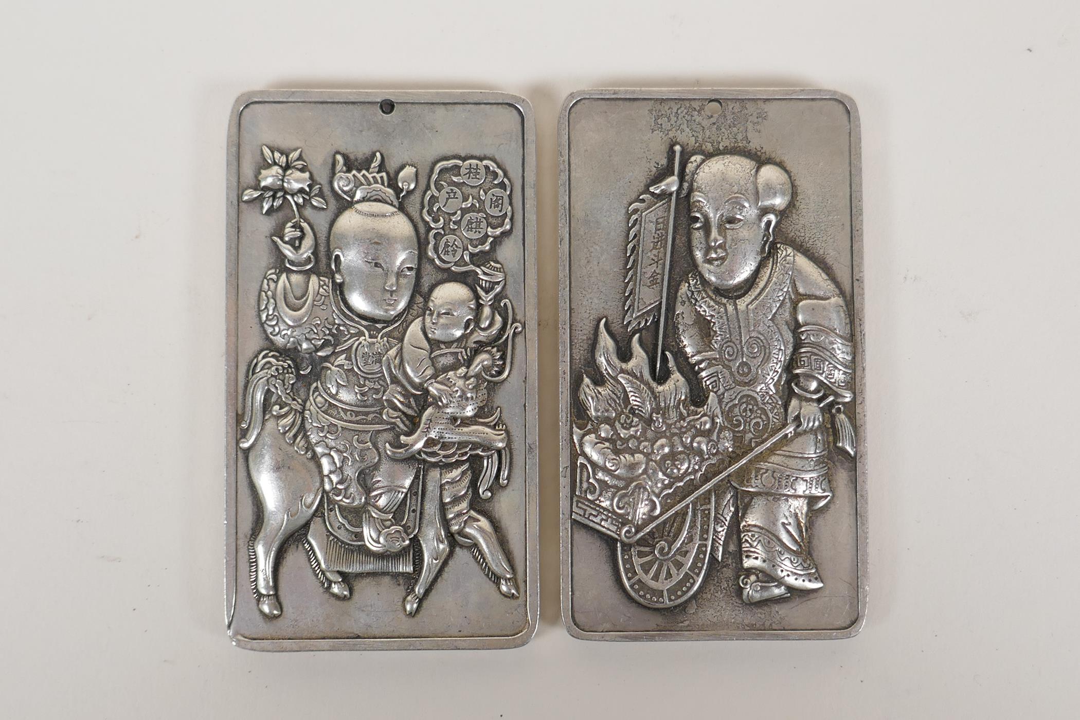 A pair of Chinese white metal scroll weights with figural decoration, 2" x 3½"