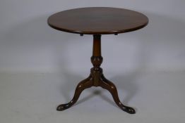 A Georgian mahogany tilt top occasional table, raised on a turned column and tripod supports with