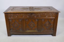 An C18th oak triple panel coffer with carved decoration, raised on moulded stile supports, 44" x 22"