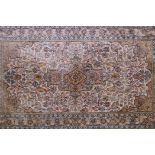 A cream ground oriental rug, with a floral medallion design and borders, 61" x 35"