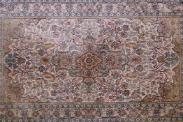 A cream ground oriental rug, with a floral medallion design and borders, 61" x 35"