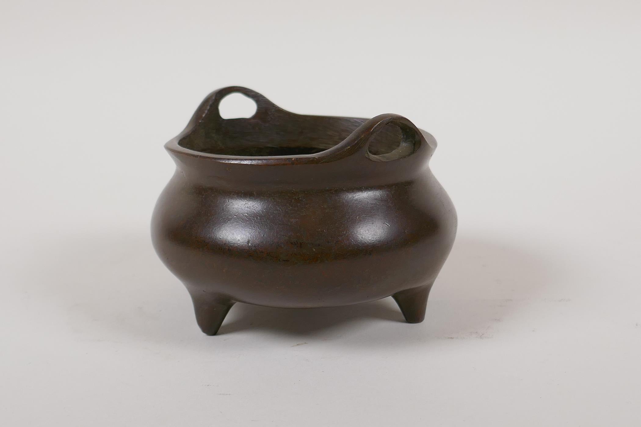 A Chinese bronze censer with two phoenix eye handles and tripod supports, impressed 4 character mark - Image 2 of 4