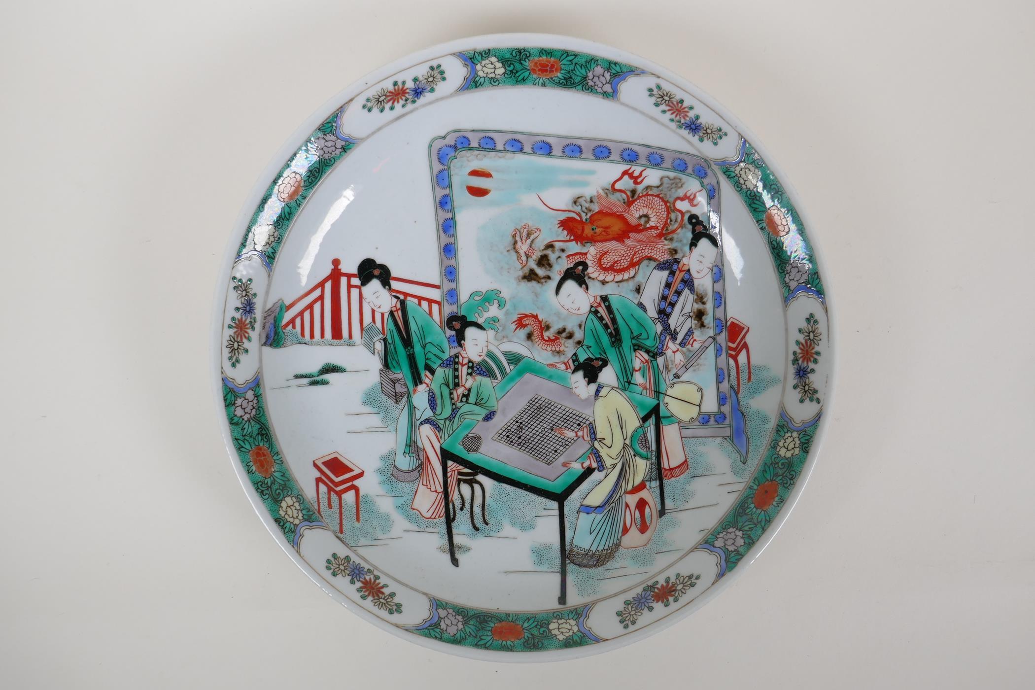 A famille vert porcelain charger decorated with women playing go, Chinese KangXi mark to the base,