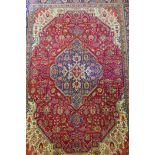 A large red ground Persian Tabriz carpet with geometric medallion design, 99" x 137", AF repairs