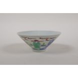 A Chinese Doucai porcelain conical bowl decorated with figures in a garden, 6 character mark to