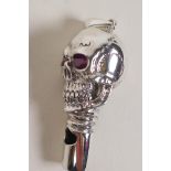 A sterling silver whistle modelled as a skull with ruby eyes