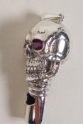 A sterling silver whistle modelled as a skull with ruby eyes