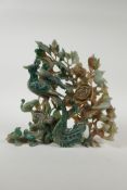 A Chinese mottled green hardstone carving depicting a phoenix and other asiatic birds amongst