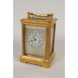 A miniature brass cased carriage clock with Sevres style porcelain panel and dial, with key, 2½"