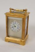 A miniature brass cased carriage clock with Sevres style porcelain panel and dial, with key, 2½"