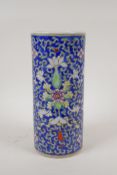 A Chinese polychrome porcelain cylinder vase with scrolling lotus flower decoration on a blue