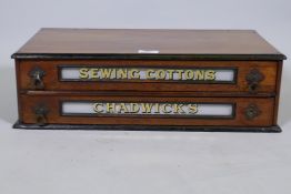 A Chadwicks Sewing Cottons antique walnut shop display case, with two drawers and eglomise panels,