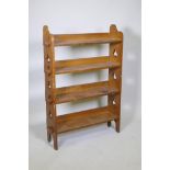 An early C20th Arts & Crafts style oak open bookcase, with peg jointed shelves and pierced trefoil