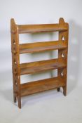 An early C20th Arts & Crafts style oak open bookcase, with peg jointed shelves and pierced trefoil