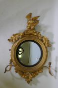 A Regency convex wall mirror with dragon crest and two candle sconces, bears label verso Joseph