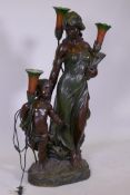 An Art Nouveau style bronzed composition three branch floor lamp in the form of maiden with child,