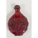 An oriental faux amber snuff bottle with leaf and vine decoration, 3" high