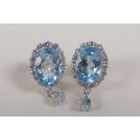 A pair of 925 silver drop earrings set with a large blue topaz encircled by cubic zirconia, 5cts