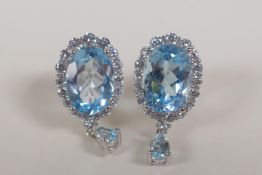 A pair of 925 silver drop earrings set with a large blue topaz encircled by cubic zirconia, 5cts