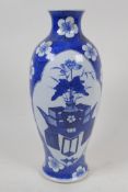 A Chinese blue and white porcelain vase with painted panels of flowers on a table, on a floral and