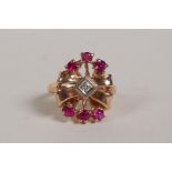 A 14ct rose gold lady's ring in the form of a bow, set with a diamond and rubies, size K